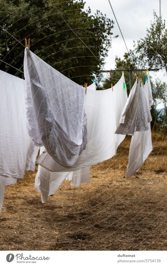 Laundry hung out to dry flutters in the wind Washing day leash Clothesline Tumble dryer Clean polish Blow Dry cleaning Sheet Cleanliness Backyard clothespin