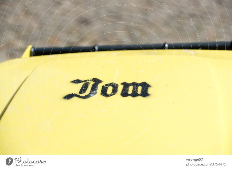 Lid of a yellow drum with the inscription Dom ton yellow ton dustbin lid Dome Inscription label Trash Exterior shot Colour photo Recycling