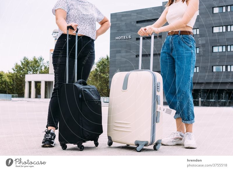 two unrecognizable tourists with their bags in front of the hotel where they are going to stay luggage hotels hostage tourism vacations transport public journey
