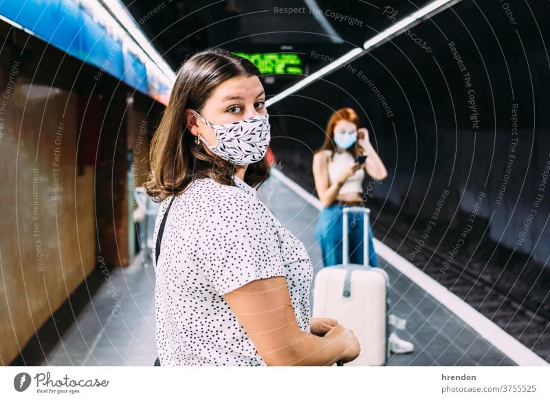 young woman with a face mask waiting for the subway transportation public journey tourist trip commuter train traveling voyage economy virus coronavirus