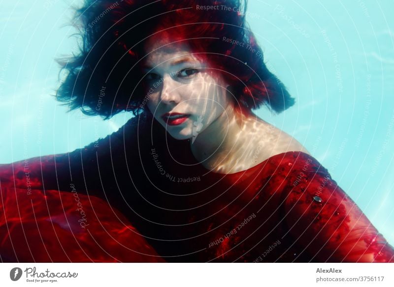 Young woman in red ball gown dives in a swimming pool Woman girl already daintily Athletic Sunlight Summer swimming pools Water Aquatics Desirable Adults