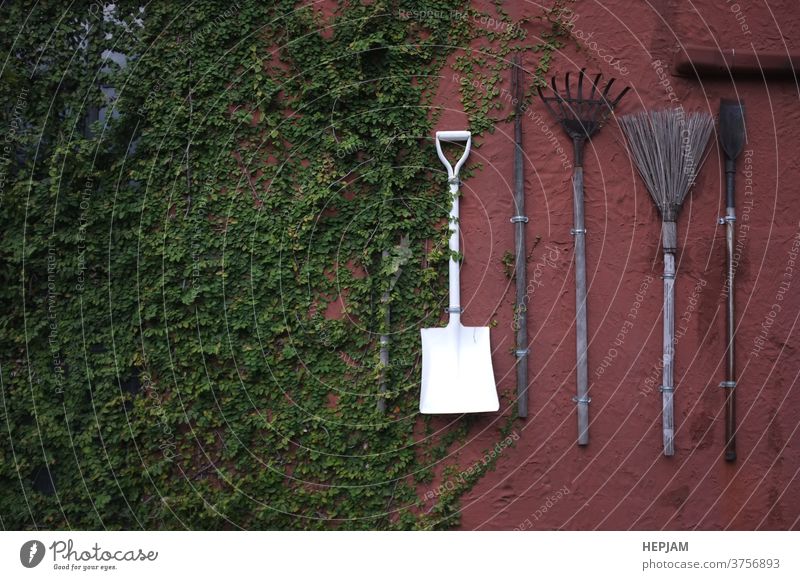 The gardening tools hanging on red cement wall. aged agriculture ancient background design dirty equipment farm farmer farming fork grass green group grunge