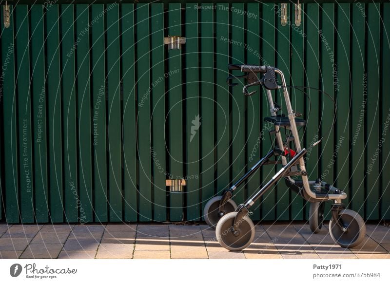 Lonely rollator in front of a green wooden wall Rollator Walking aid Senior citizen Exterior shot Old Mobility handicap aids mobile Healthy Wall (building)