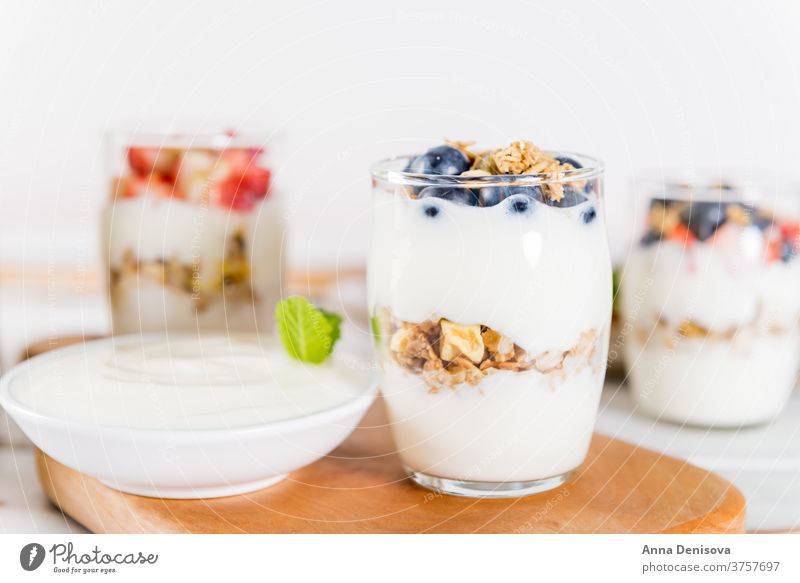 Little Jars with layered dessert from natural yogurt, granola an breakfast healthy muesli food fruit meal white sweet fresh bowl organic greek wooden cereal