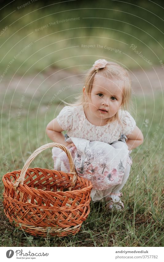 little cute girl with a basket enjoys a sunny day in the park kid happy baby portrait playing happiness beautiful candid carefree cheerful child childhood