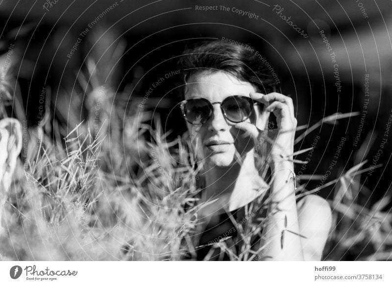 surprised, the woman looks into the camera and grabs her sunglasses Meditative portraite Face of a woman Adults 18 - 30 years Feminine Women's eyes already