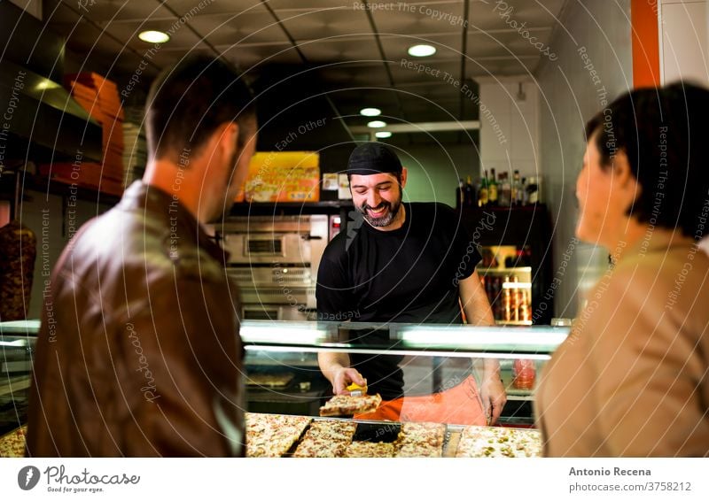 Couple buying and choosing pizza at street outdoors restaurant. man turkish adult person people lifestyle attractive men male bearded seller store junk food