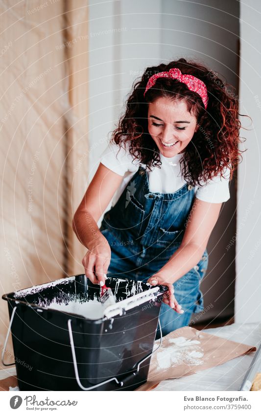 happy caucasian woman painting the room walls with white color. Do it yourself and new home concept house brush young new house painter bricolage america solo