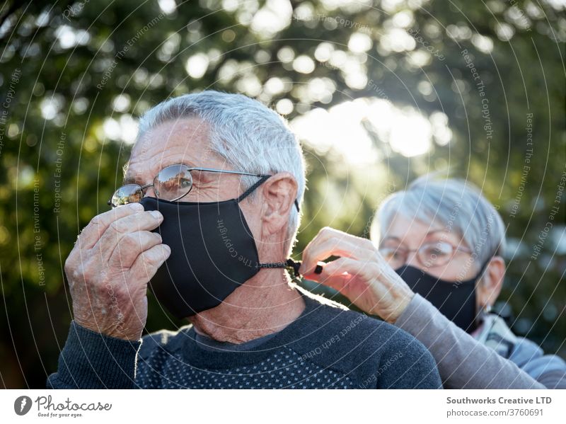 Active senior couple on outdoor walk wearing face masks elderly covering mature happy love outdoors retired active caucasian copy space female man old partner