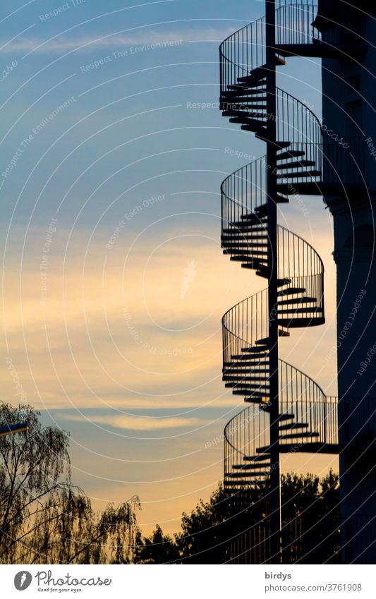 spiral staircase at a building in front of a beautiful evening sky. spiral staircase Winding staircase External Staircase spirally Evening Spiral Handrail