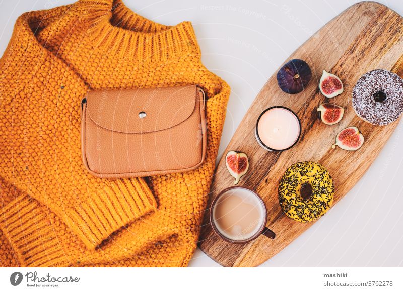 cozy autumn morning flat lay composition with warm sweater, cup of coffee, sweet donut for breakfast and fashion handbag fall winter decoration drink knitted