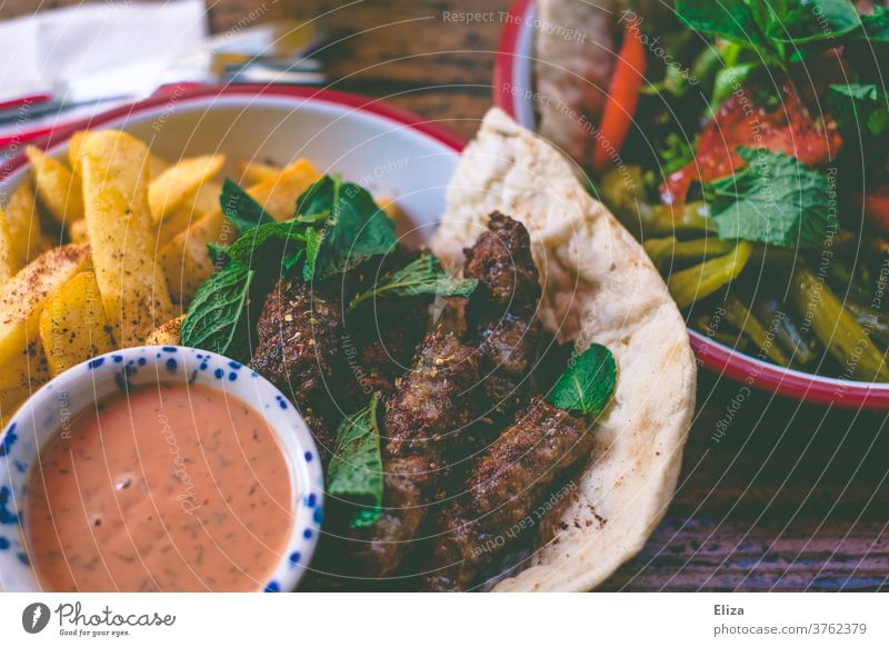 Could (Köfte) with chips and salad - Oriental food köfte fries Lettuce Meal oriental Turkish Eating Delicious Meat sauce Lunch Dinner Close-up Food Wooden table