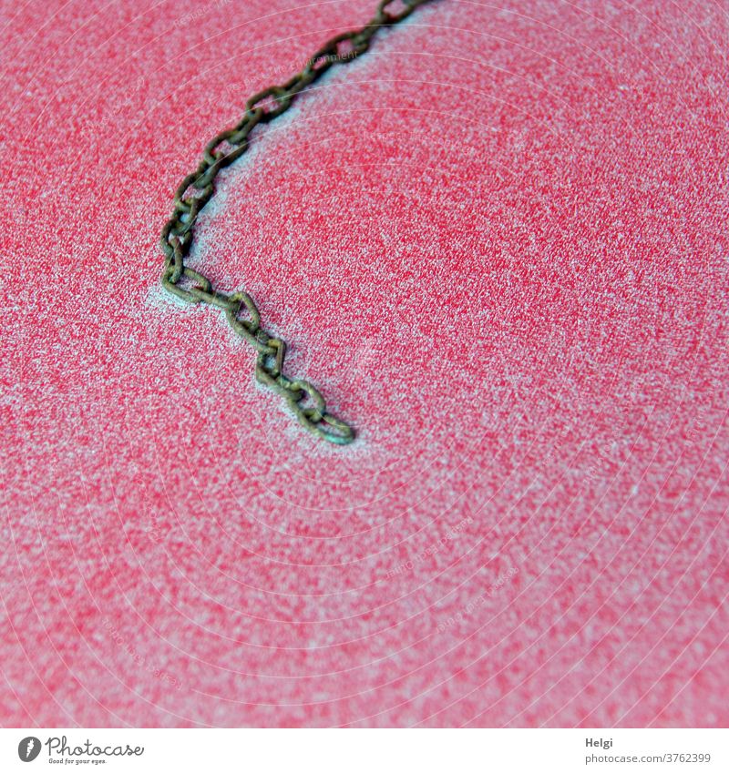 sandy - metal link chain lies on a red plastic surface covered with fine sand Chain metal chain Metal Sand drifting sand Exterior shot Chain link Deserted