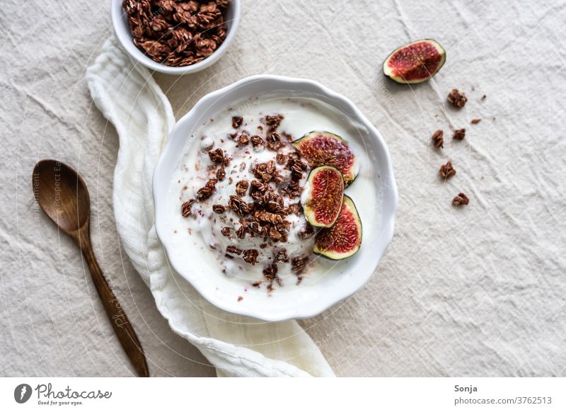 Granola with yoghurt and fresh figs in a bowl on a beige linen cloth. Outside view, healthy breakfast. granola Yoghurt Breakfast Fig Spoon fruit Rustic