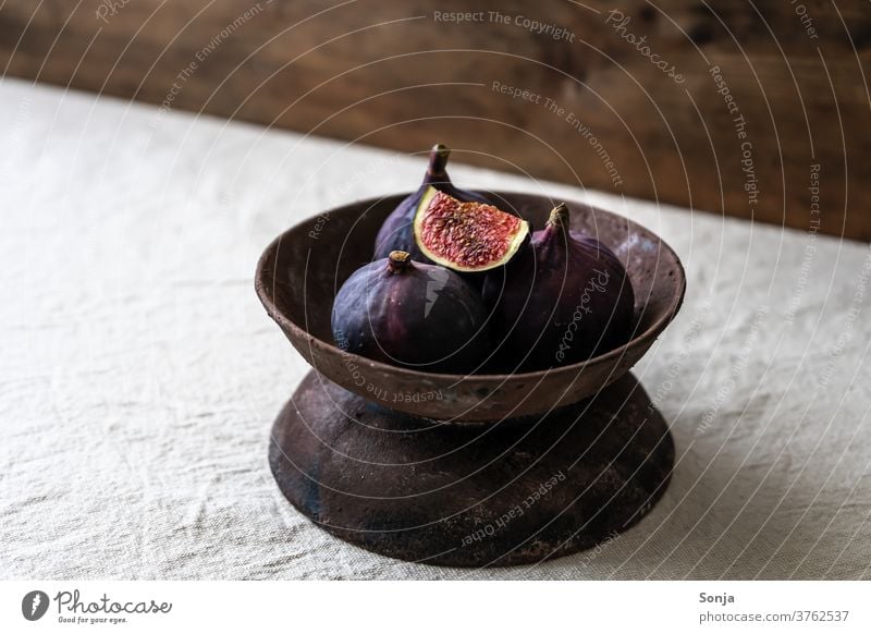 Fresh figs in a rustic bowl on a beige linen tablecloth. Fig bowl fruit bowl Rustic Raw Healthy Mature Organic natural Diet Table wood Nutrition Ingredients
