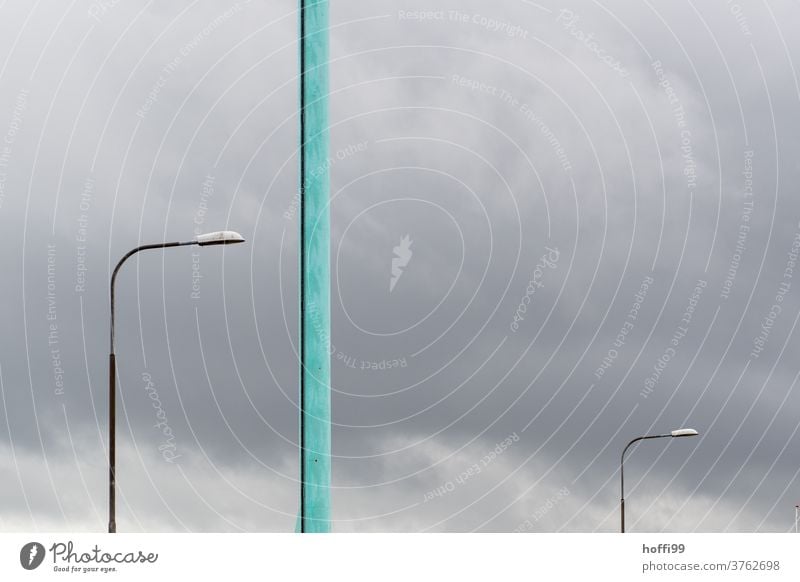 two lamps and a turquoise pole in front of a grey sky - a storm is coming Turquoise street lamp whip lamps Lamp Minimalistic Sky Colour photo stormy