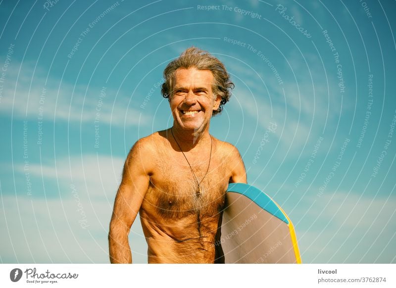 mature surfer practicing surfing on the coast of the basque country, spain senior man water people adult board surfboard neoprene surfboarder beach lifestyle