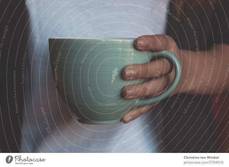 Tea mug or coffee cup held by the hand of a young woman. Close-up with natural window light teacups Tea cup Coffee mug Hot drink Coffee cup stop Retentive