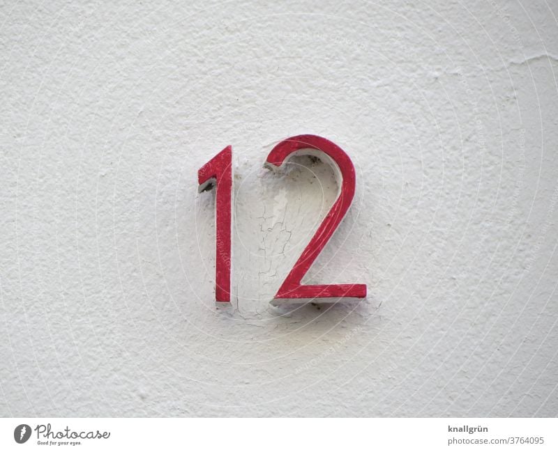 Red house number 12 on a white house wall House number Digits and numbers Wall (building) Facade Signs and labeling Wall (barrier) Exterior shot Colour photo