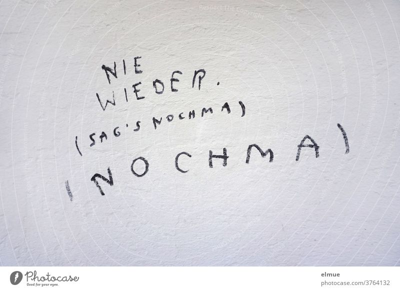 "NEVER Say NOCHMA" is written in block letters in black on the gray wall never again Daub Repeating quibbling Say it again opinion formation reenact Spelling
