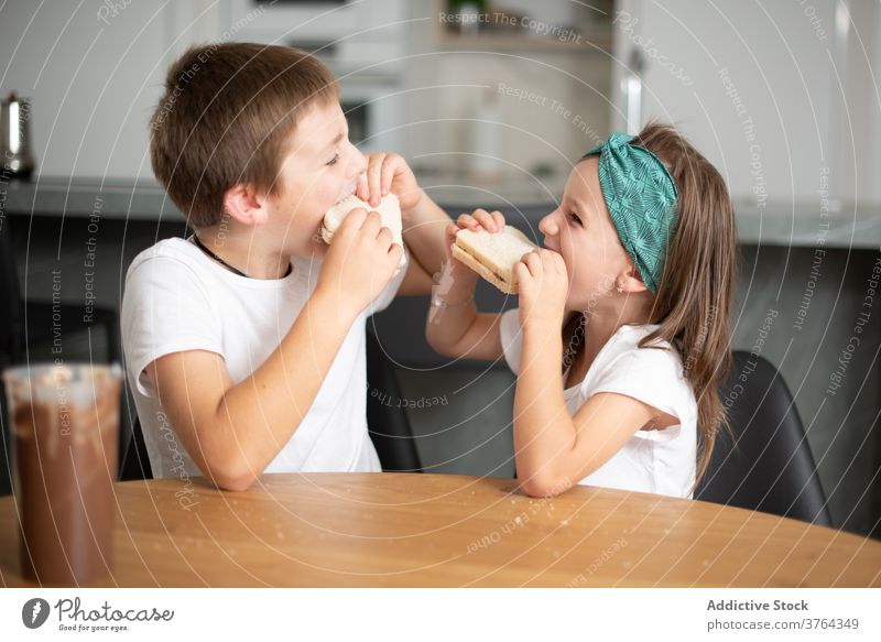 Siblings eating chocolate bread girl boy excited child amazed children cheerful food preteen optimistic positive breakfast mouth fun female sweet happy young