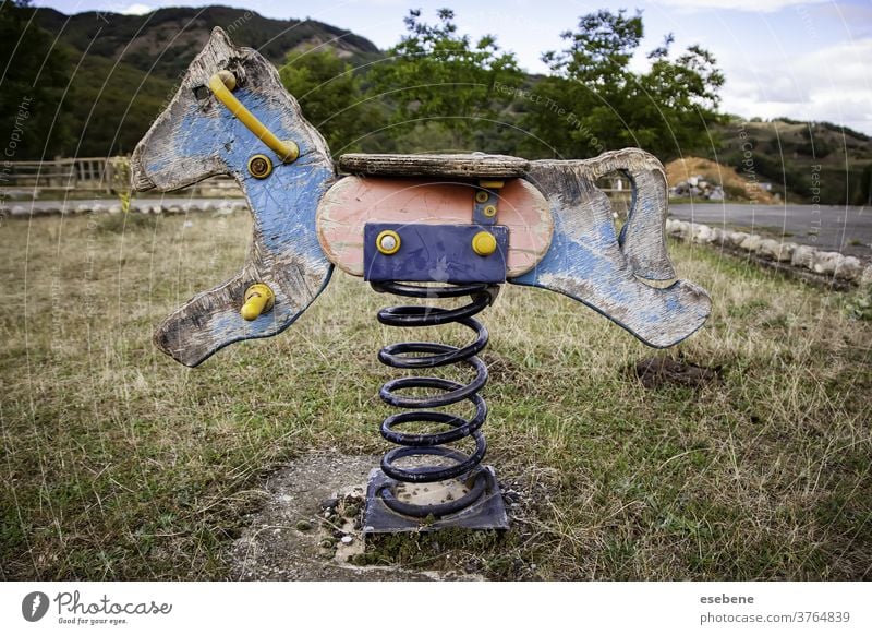 Abandoned rocking horse in playground white antique lonely isolated ride joy attraction wooden spring kindergarten seesaw broken aged chair cute weathered