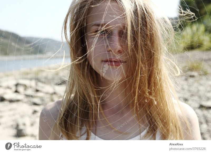 Close up backlight portrait of a young, freckled woman with wind-blown hair on the banks of the Rhine Woman Young woman Slim already athletic Blonde youthful