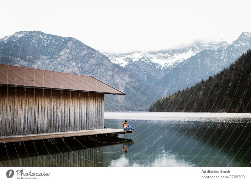 Woman on wooden pier near lake mountain traveler woman wanderlust relax solitude highland reflection pond female germany austria quay scenery calm tranquil snow