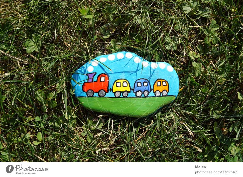 A painted hiking stone is left on the walking path for passersby to see park adventure background border cartoon child clearing climb color creature design