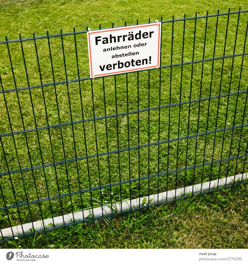 Prohibition sign on fence Fence Arrangement German square Signs and labeling Bans Exterior shot green Lawn Grass neighbourhood Meadow Deserted Barrier Border