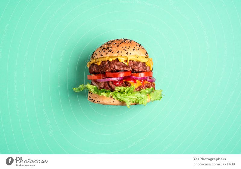 Hamburger on a green background, top view. Burger side view. above view barbeque bbq beef big bread bun cheddar cheese cheeseburger comfort food copy space