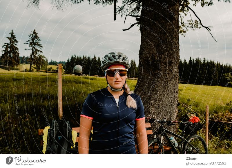 Portrait of a female cyclist on a cycling tour in the countryside bike tour Cyclist Mountain bike Nature Landscape Tree Meadow Bavaria Helmet Sunglasses