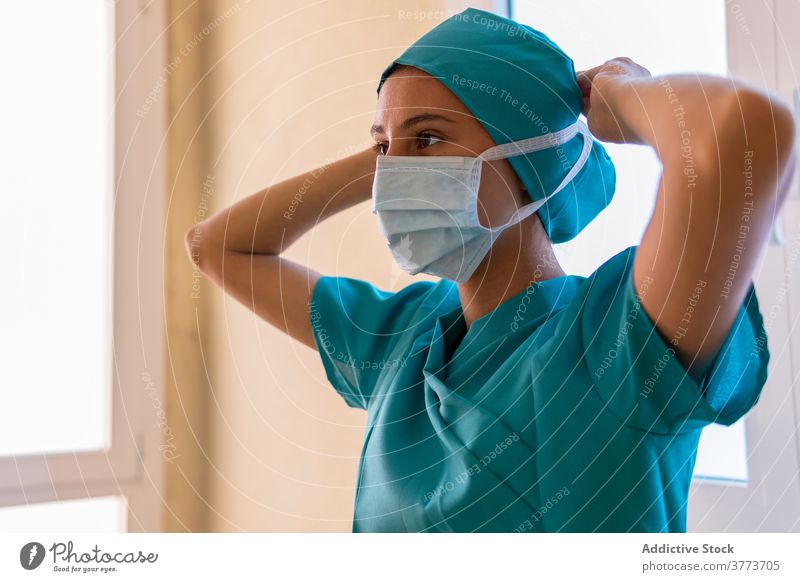 Female medic putting on mask in hospital put on doctor nurse coronavirus woman covid 19 medical face mask uniform female work clinic specialist medicine protect