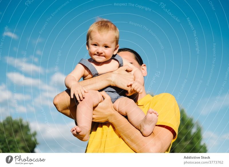 Young man playing with toddler in park father child together summer having fun adorable idyllic innocent weekend kid little enjoy relax childhood happy cheerful