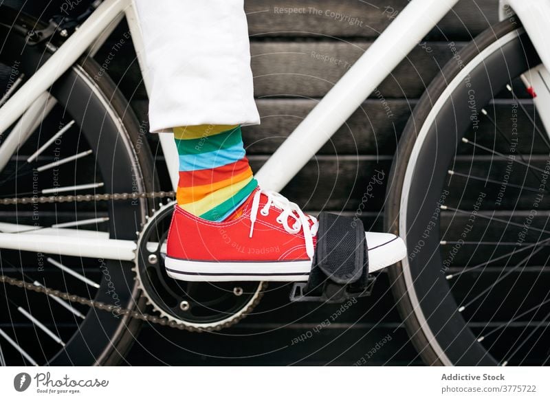 Crop person in colorful socks on bicycle stripe rainbow creative fun bike vehicle modern city street urban style trendy transport town hipster outfit cool