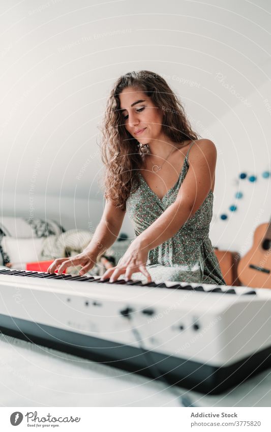 Woman playing piano in living room music musician woman rehearsal talent skill creative melody ethnic female modern apartment song perform sound entertain sit
