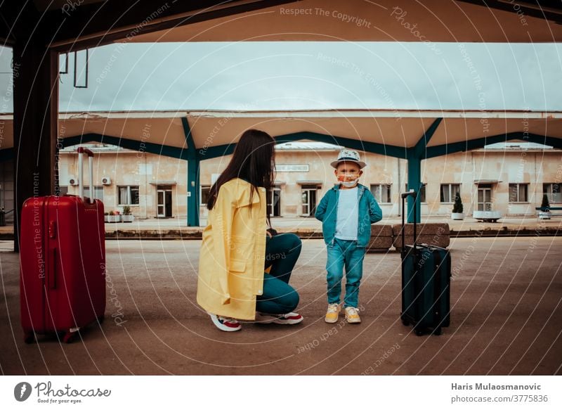 Mother and child traveling with face mask on railway station adult bag baggage bags beautiful caucasian city corona virus covid travel covid-19 destination