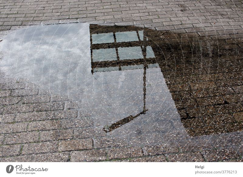 Lantern, glass roof and wall in front of a cloudy sky are reflected in a puddle reflection Puddle Paving stone Water Wet Glass roof Wall (building) Sky Clouds