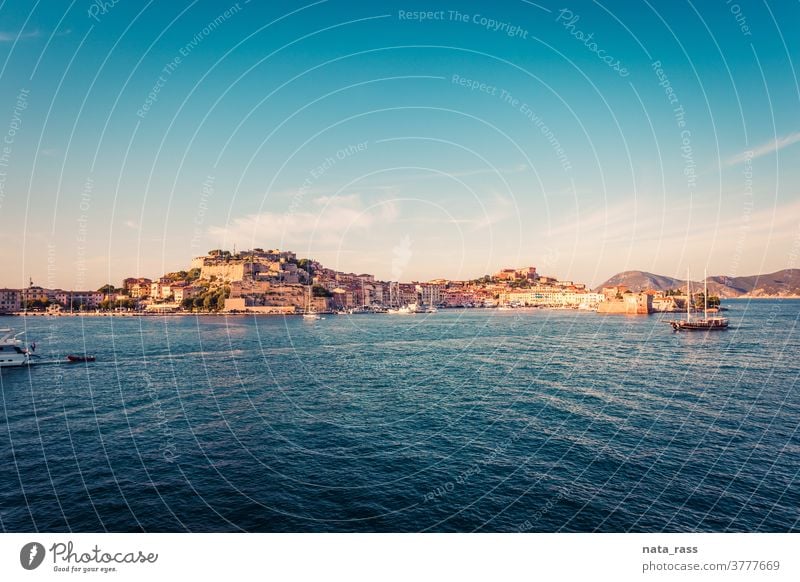 Panoramic view on Portoferraio ancient fortification in golden light on island Elba sunset architecture mediterranean port vacation lighthouse tuscan building