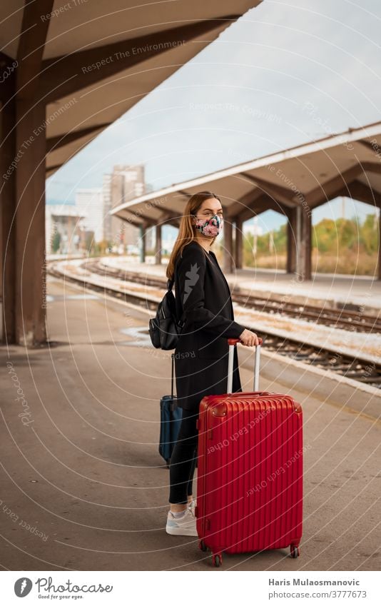 Woman with mask and travel bag waiting on public train station adult attractive baggage beautiful business caucasian city coronavirus covid-19 female journey