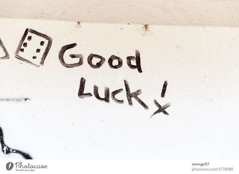Good Luck ! written with black paint on a white wall Graffito writing authored good luck black color white background Colour photo Deserted Characters