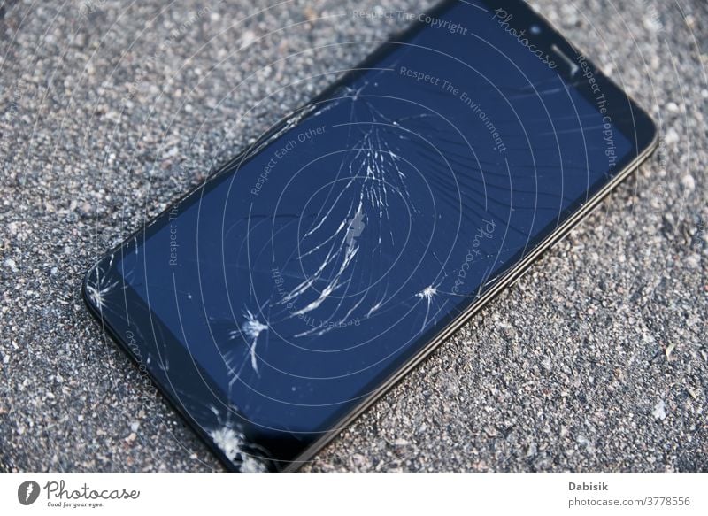 Damaged smartphone with broken touch screen on asphalt damage cell fall tablet floor mobile street crack smashed cellphone modern scratch ground electronic
