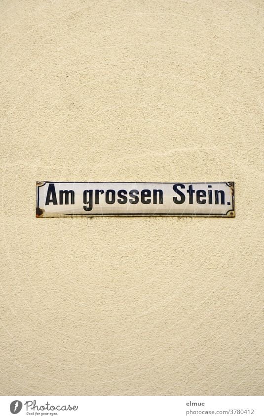 Street sign "Am großen Stein" on a beige house wall At the big stone street name street sign Wall (building) Facade writing Signage address dwell Old bailer