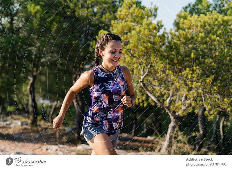 Active woman running on trail in forest mountain active workout training sport athlete positive young female nature fitness lifestyle activewear sportswear