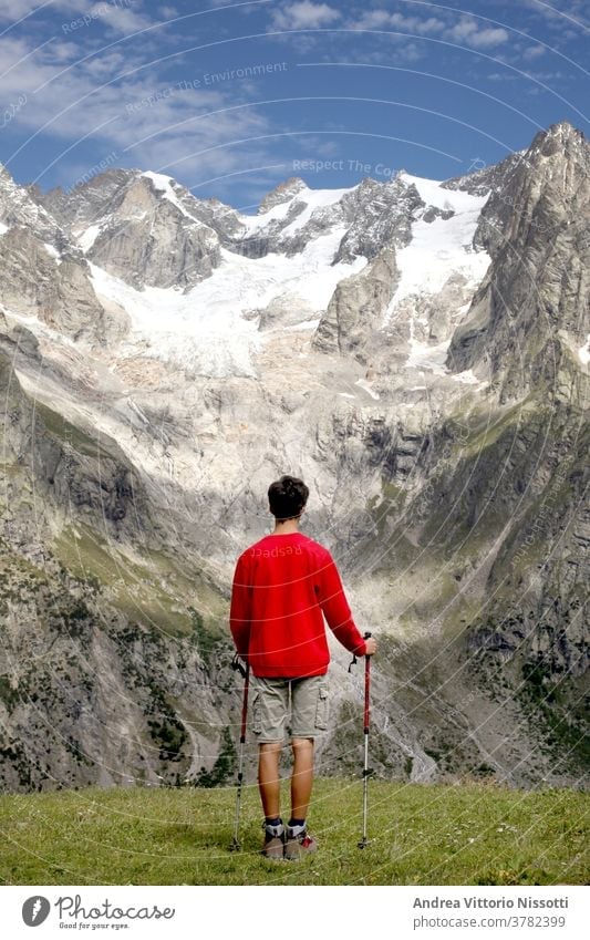 contempaltion and meditation concept: unrecognizable teenager look at a wonderful mountain landscape contemplation glacier hiking hiker male caucasian boy alone