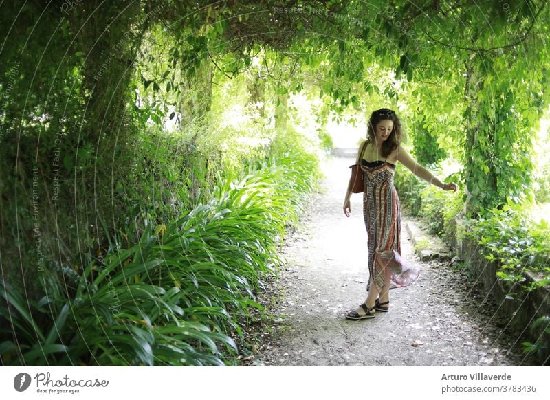 portrait of a girl in a long dress surrounded by plants hair female posing luxury lady healthy multicolored colour stylish clothes vogue sexy sensual park