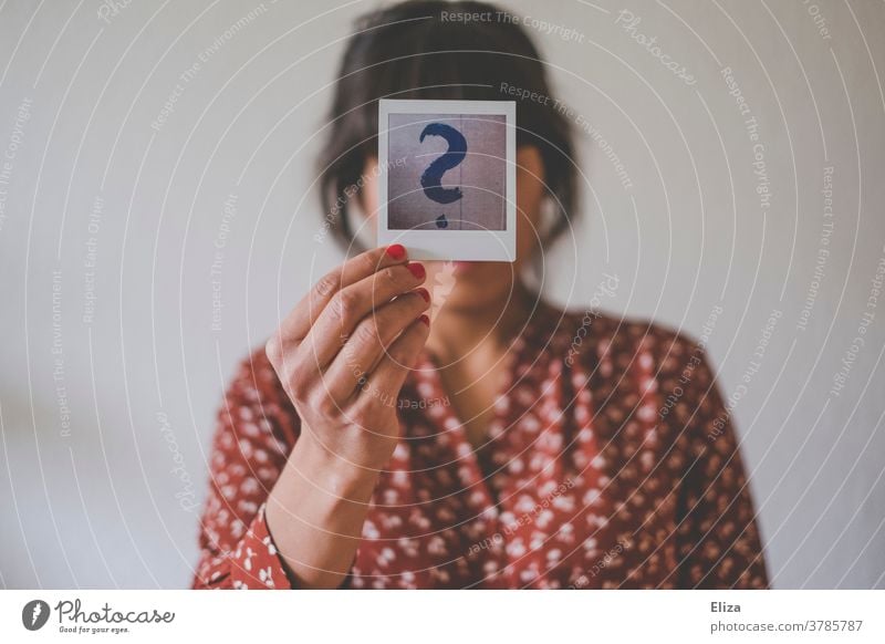 Identity crisis. Young woman holds a Polaroid with a big question mark in front of her face. identity crisis Human being Woman Question mark helpless Insecure