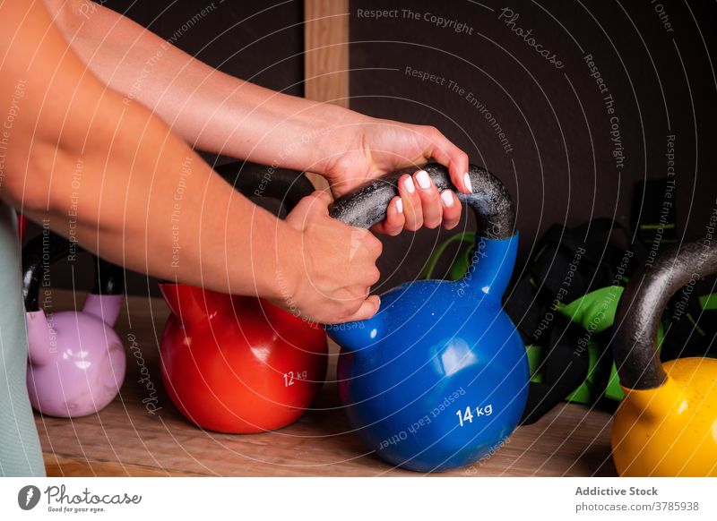 Crop woman during training in gym with kettlebells sportswoman strong heavy equipment metal exercise muscular female athlete fit healthy wellbeing effort