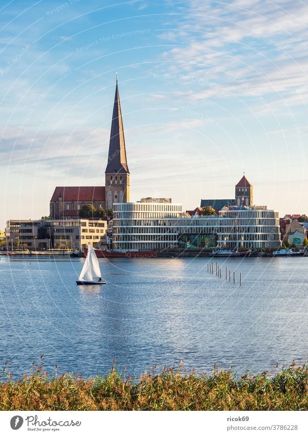 View of the Hanseatic City of Rostock with Petrikirche, Nikolaikirche and Silohalbinsel Sailboat Warnov River city harbour Mecklenburg-Western Pomerania Town