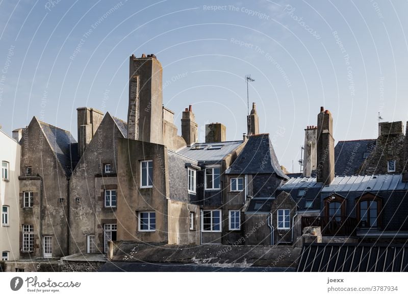 Facades of historic houses with chimneys in an old town Wall (barrier) Window Fireplaces Roof Sky Blue Village Old town Saint Malo France Brittany